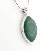 Green malachite pendant on a silver chain against a white background