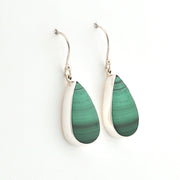 Green teardrop earrings with silver hooks on a white background