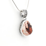 Silver pendant with a red and white stone on a white background