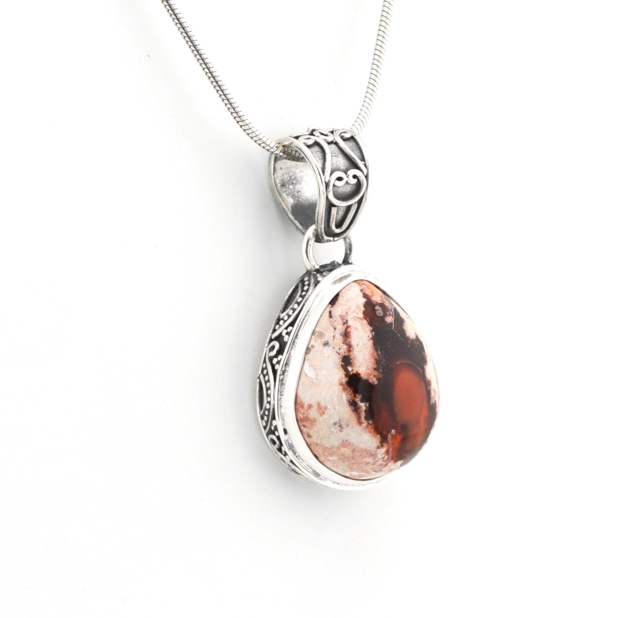 Silver pendant with a red and white stone on a white background