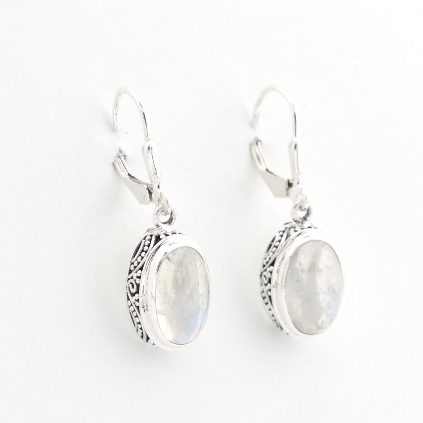 Pair of silver earrings with moonstone stones on a white background