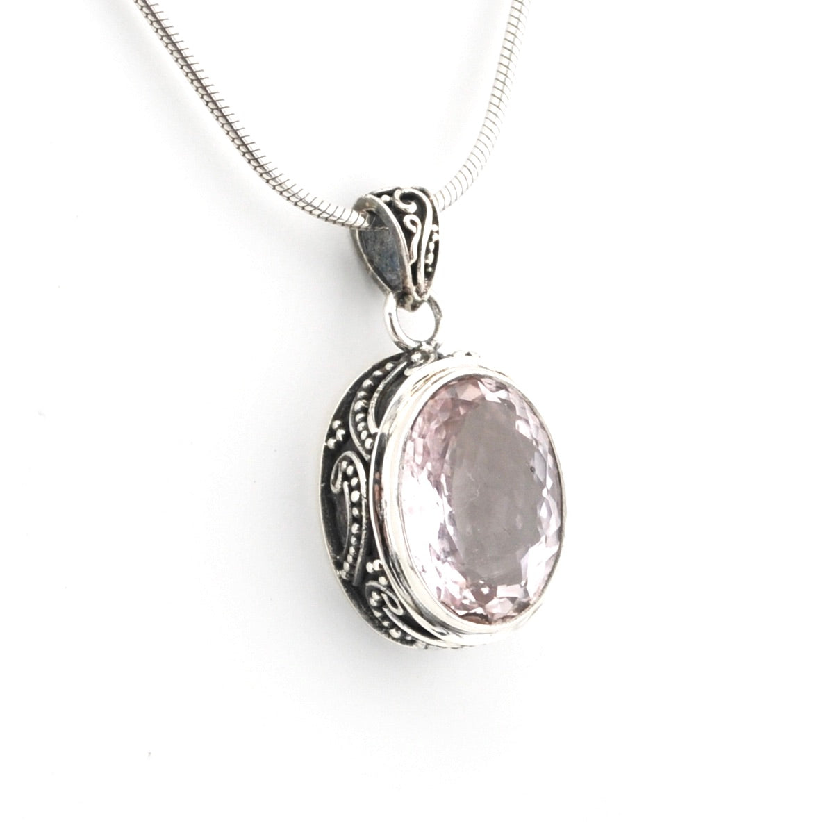 Silver pendant with a pink stone on a white background