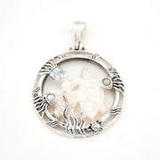 Silver pendant with a turtle design and gemstones on a white background