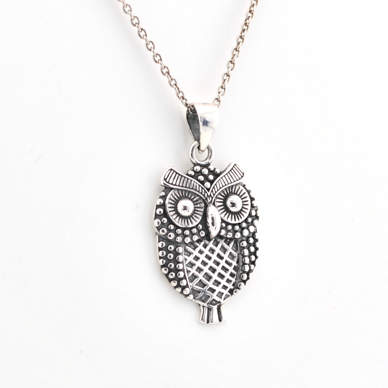 Silver owl pendant necklace on a white background