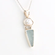 Necklace with a pendant featuring a  pearl and sea glass on a white background
