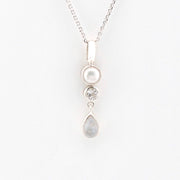 Silver necklace with three pendant drops on a white background