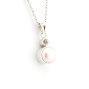 Pearl necklace with a silver chain on a white background