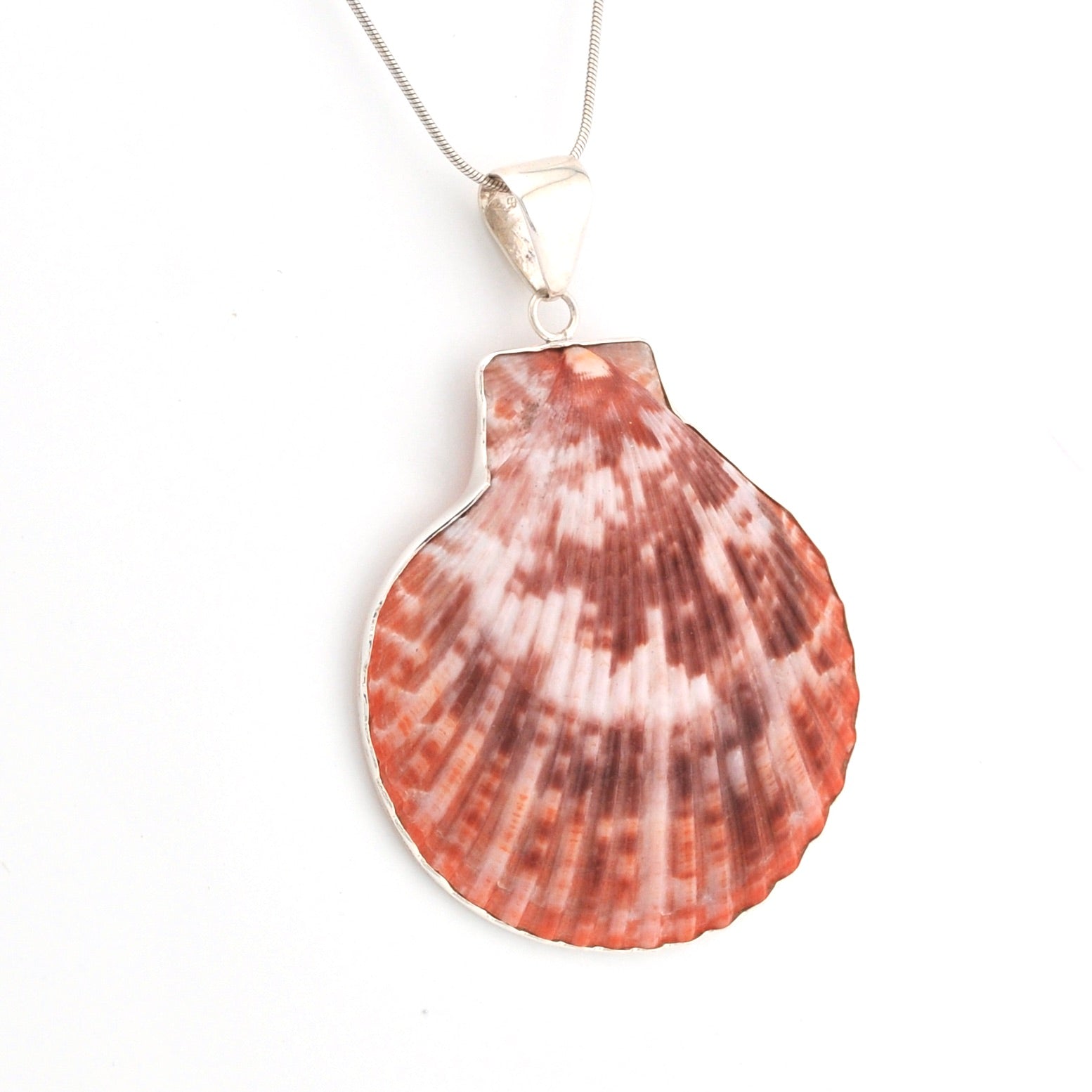 Handmade shell pendant with silver on a white background