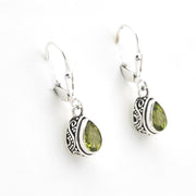 Silver earrings with green gemstones on a white background