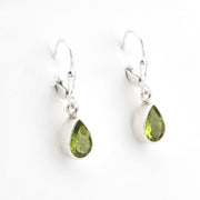 Silver earrings with green teardrop stones on a white background