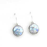 Pair of silver earrings with round, faceted gemstones on a white background