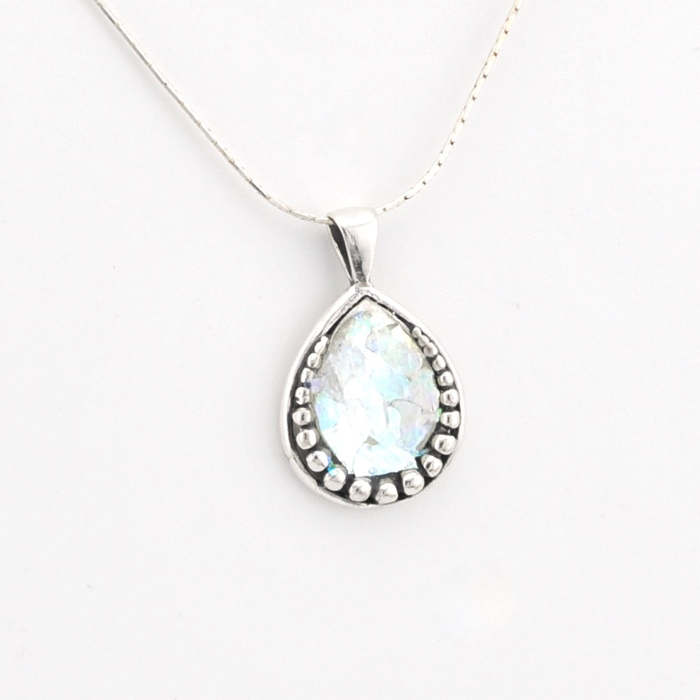 Teardrop-shaped pendant with a white stone on a white background