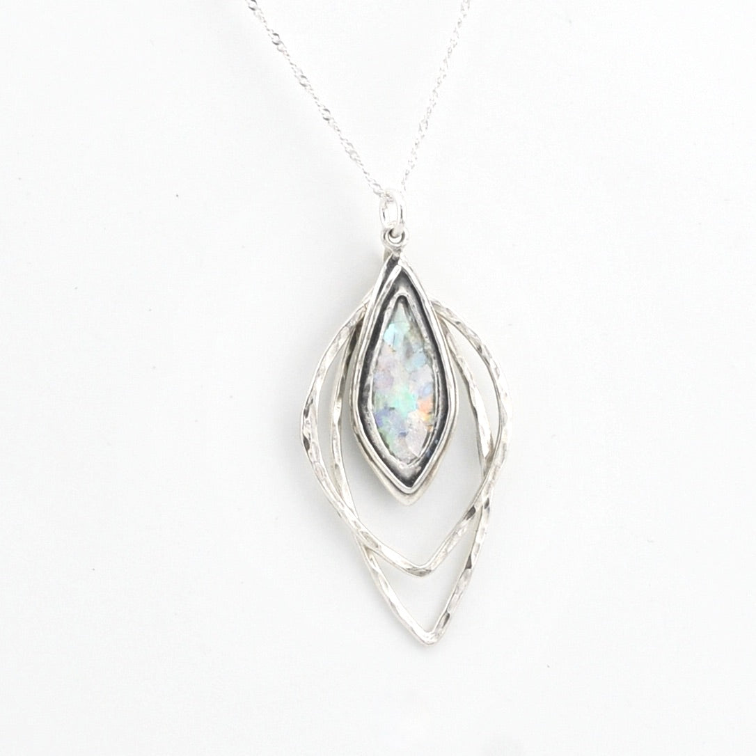 Silver pendant with Roman glass on a white background
