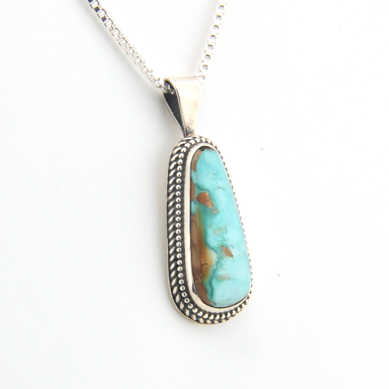 Turquoise pendant necklace on a white background