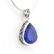 Teardrop-shaped blue gemstone pendant on a white background