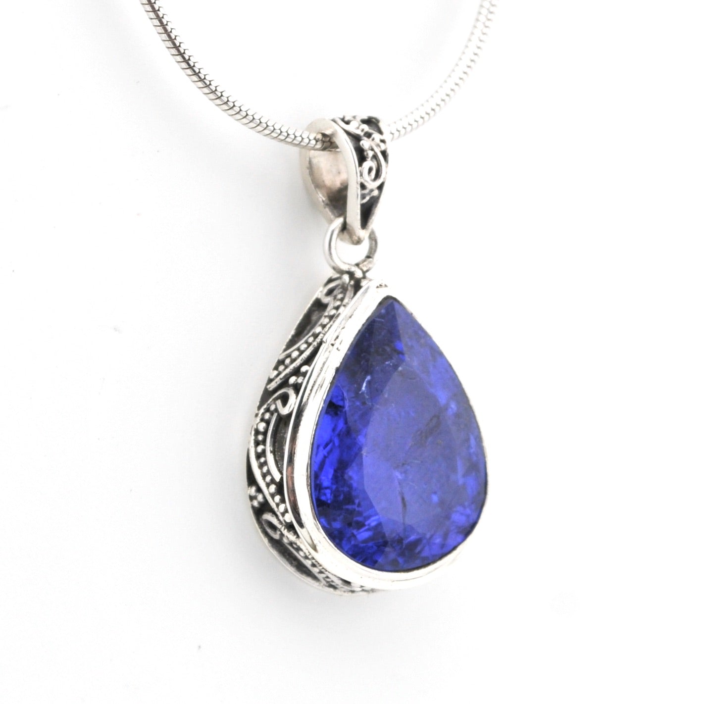 Teardrop-shaped blue gemstone pendant on a white background