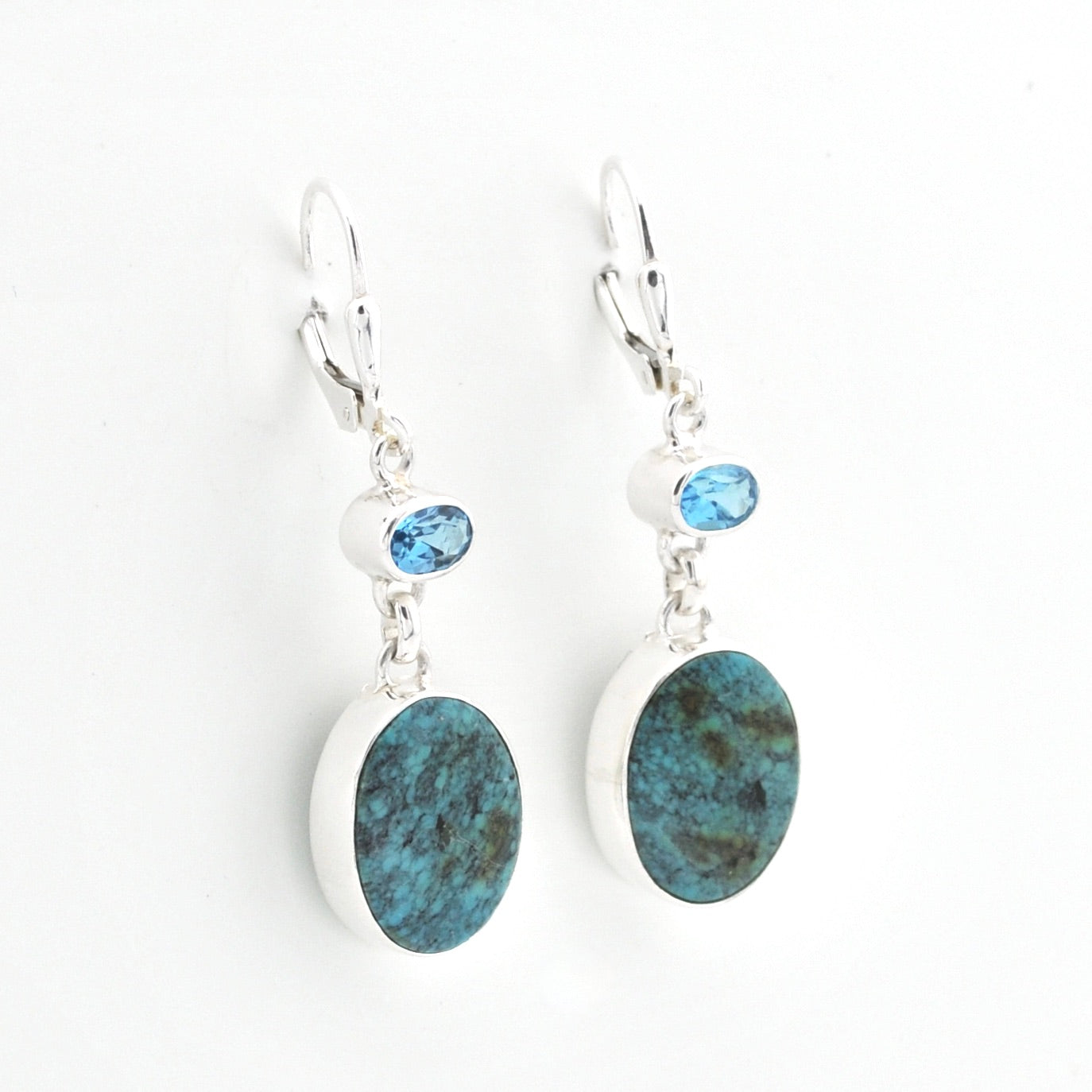 Pair of earrings with blue stone drops on a white background