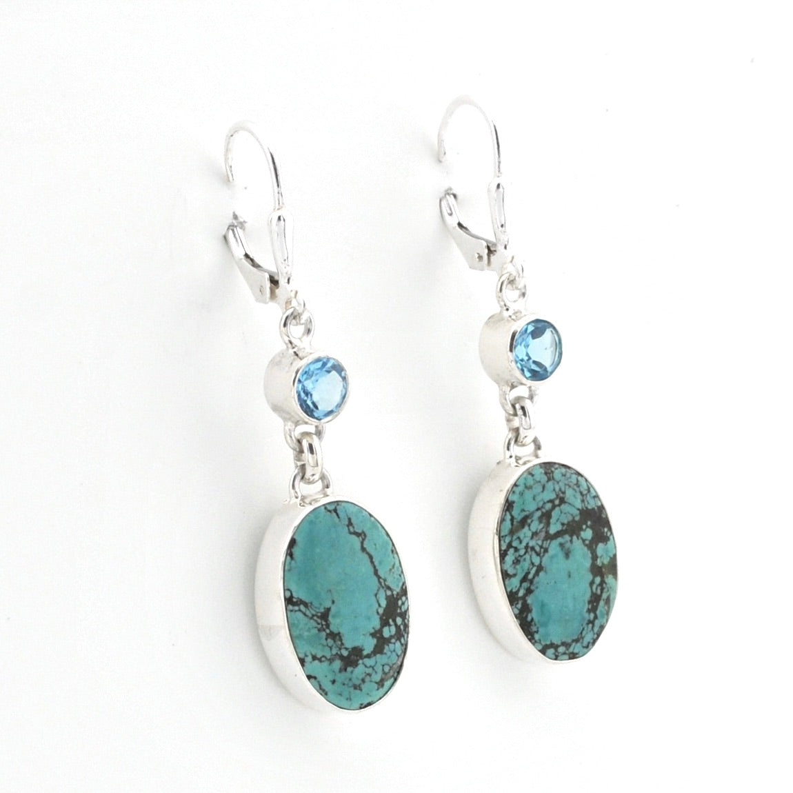 Pair of earrings with turquoise stones and blue gemstones on a white background