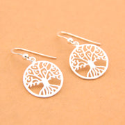 Silver tree-of-life earrings on a beige background