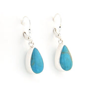 Teardrop-shaped blue earrings with silver hooks on a white background