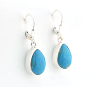 Teardrop-shaped blue earrings with silver hooks on a white background