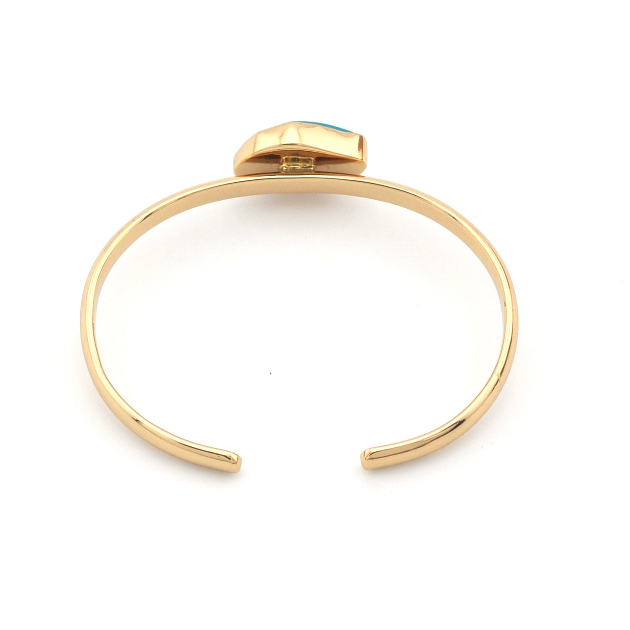 Gold bracelet with a small gemstone on a white background