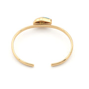 Gold bracelet with a small gemstone on a white background