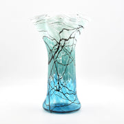Glass vase with blue and black abstract design on a white background