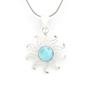 Silver sun-shaped pendant with a blue stone on a white background