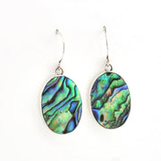 A pair of silver drop earrings featuring oval abalone shell inlays with a vibrant green, blue, and purple iridescent pattern, shown against a plain white background.