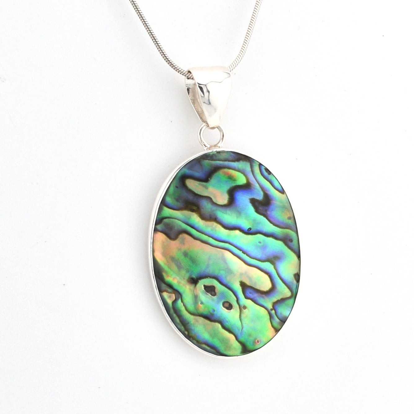 Oval abalone shell pendant on a silver chain against a white background
