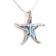Starfish-shaped pendant with abalone shell inlay on a white background