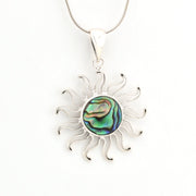 Silver sun-shaped pendant with abalone shell center on a white background