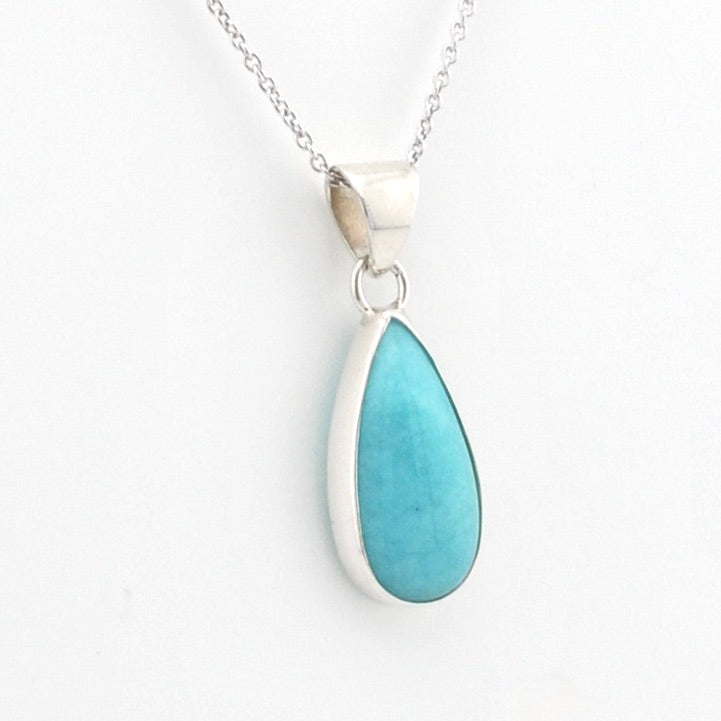 A silver teardrop pendant necklace featuring a smooth, polished light blue turquoise stone, shown on a clean white background.