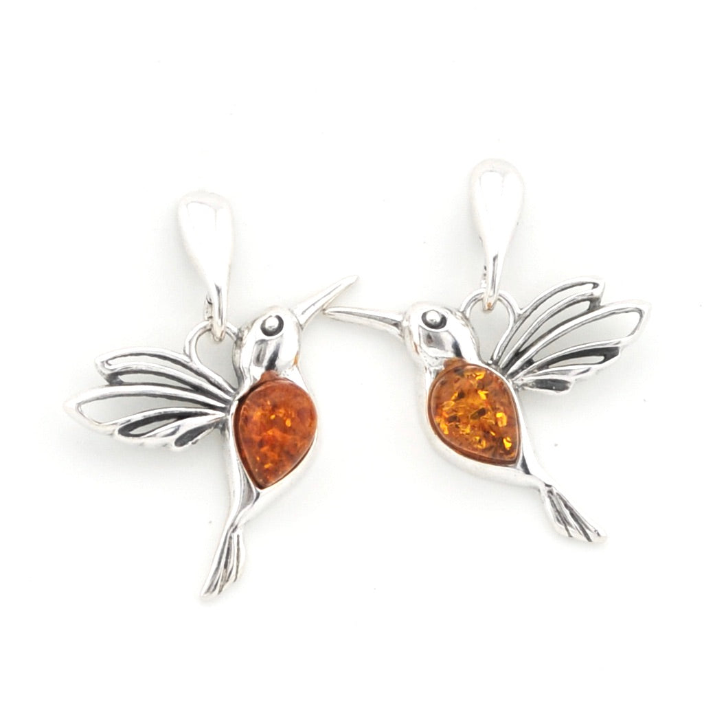 A pair of silver hummingbird earrings with polished amber-colored tear-shaped stones, shown on a plain white background.