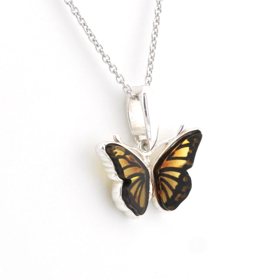 A silver butterfly pendant necklace featuring realistic orange and black wings, suspended from a delicate silver chain against a plain white background.