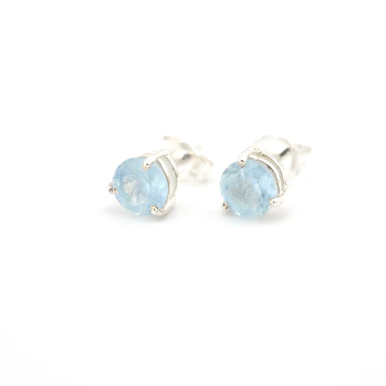 Pair of silver earrings with blue gemstones on a white background