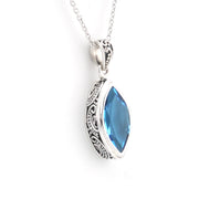 A silver filigree pendant necklace featuring a marquise-cut blue gemstone, shown on a clean white background.