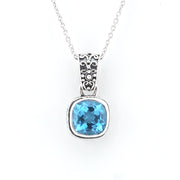 A silver pendant necklace featuring a cushion-cut light blue gemstone in a textured silver bezel setting, suspended from a delicate silver chain against a plain white background.