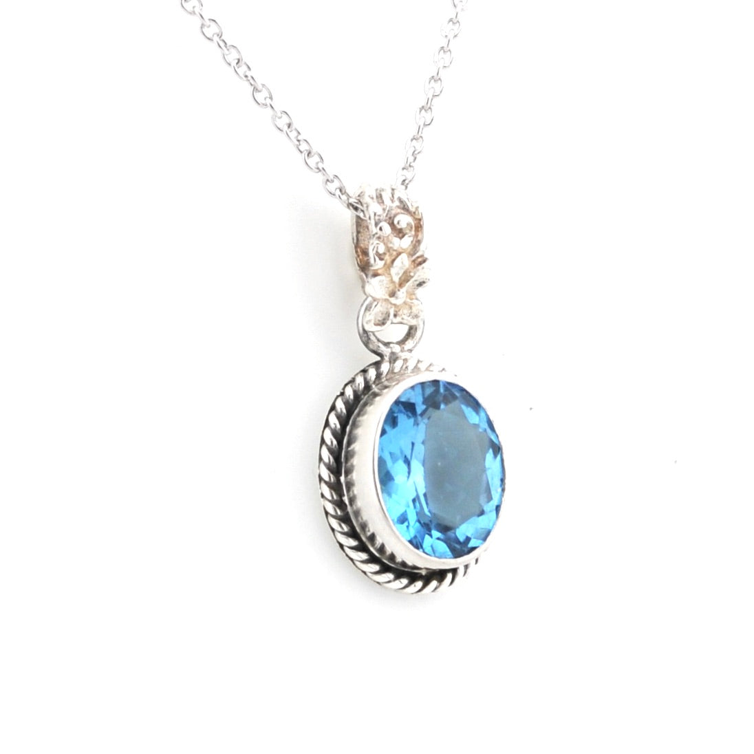 A silver pendant necklace featuring a large oval-cut light blue gemstone in a textured bezel setting, with a silver chain against a plain white background.