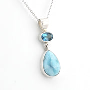 A silver pendant necklace featuring a large teardrop-shaped light blue larimar stone and a smaller oval blue gemstone, displayed on a clean white background.