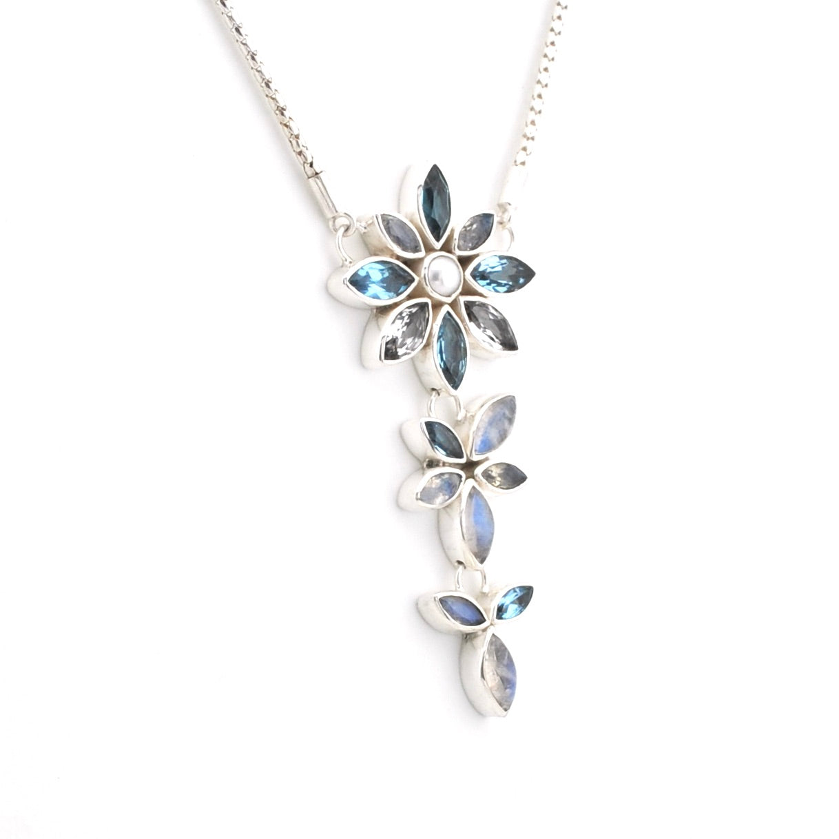 A silver-toned floral dangle necklace featuring light blue marquise-cut stones and a central white pearl, shown against a plain white background.