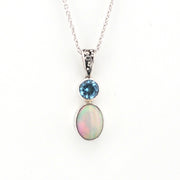Silver necklace with a pendant featuring an opal and blue gemstone on a white background