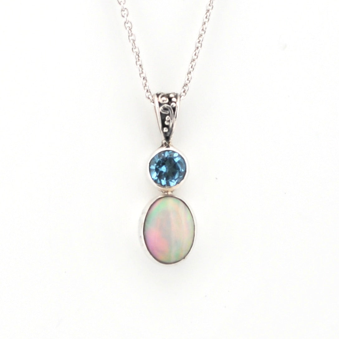 Silver necklace with a pendant featuring an opal and blue gemstone on a white background