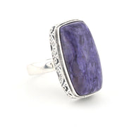 A silver ring featuring a large, rectangular purple stone with natural marbled patterns, set in an ornate silver bezel with a polished silver band, shown on a white background.