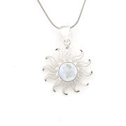 Silver sun-shaped pendant with a central circular gemstone on a white background