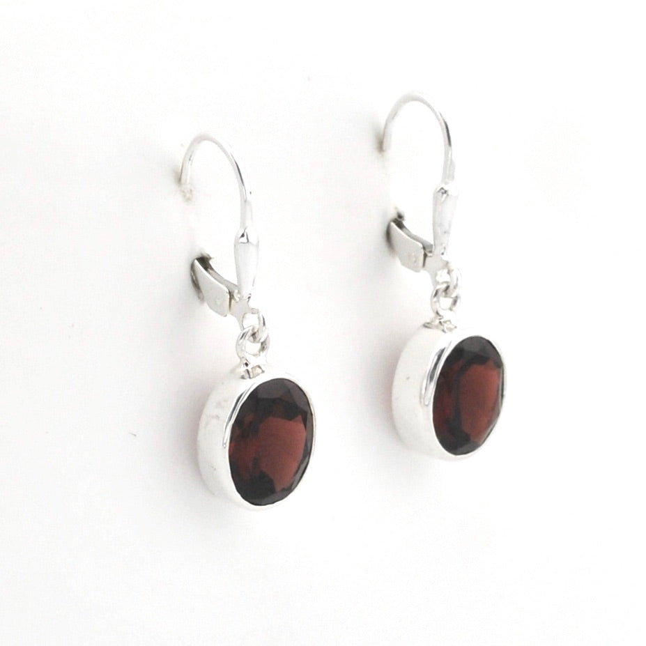A pair of silver leverback drop earrings featuring oval dark brown gemstones, displayed on a clean white background.