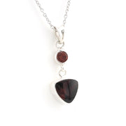 Garnet pendant on a silver chain  on a white background