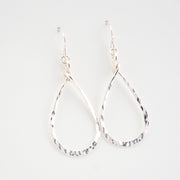 Pair of silver teardrop earrings on a light gray background