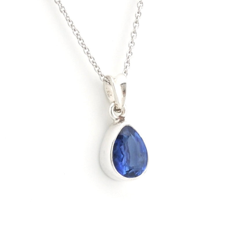 A silver teardrop pendant necklace featuring a faceted deep blue gemstone, shown on a clean white background.